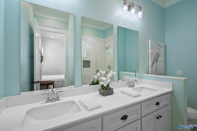 full bathroom with toilet, a stall shower, double vanity, and a sink