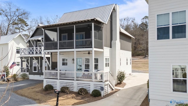 multi unit property featuring a sunroom, metal roof, driveway, and ceiling fan