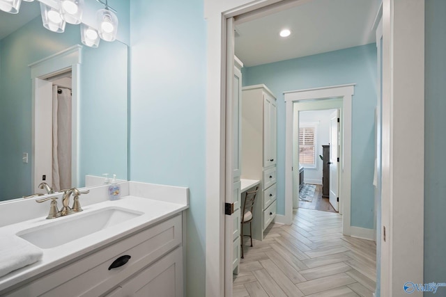 bathroom with recessed lighting, vanity, and baseboards