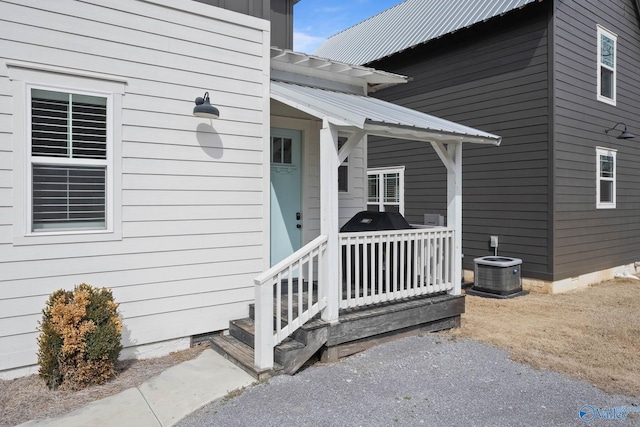 view of exterior entry with cooling unit and metal roof