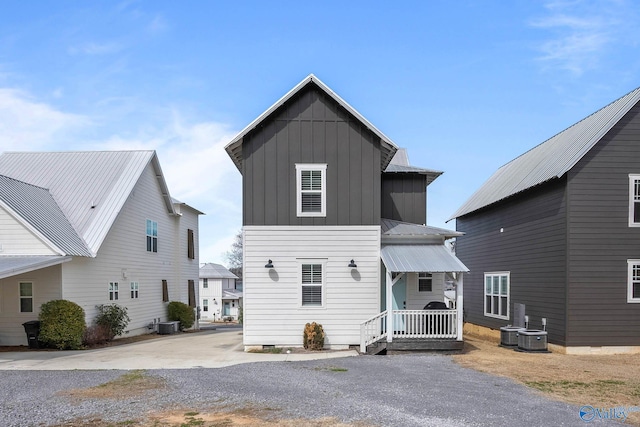 view of front of home featuring board and batten siding, cooling unit, and metal roof