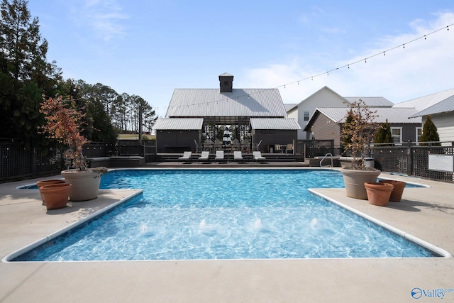 view of swimming pool featuring a patio area, fence, and a fenced in pool