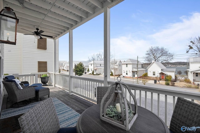 wooden deck with a residential view and ceiling fan