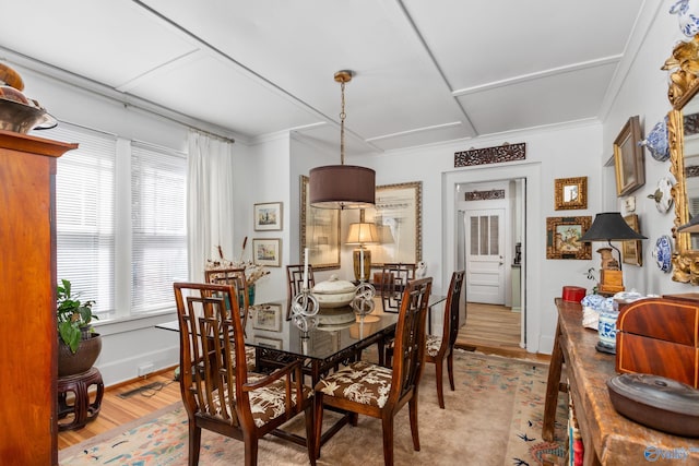 dining room featuring light hardwood / wood-style flooring and ornamental molding