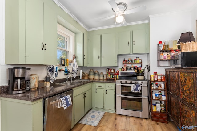 kitchen with appliances with stainless steel finishes, light wood-type flooring, green cabinetry, and crown molding