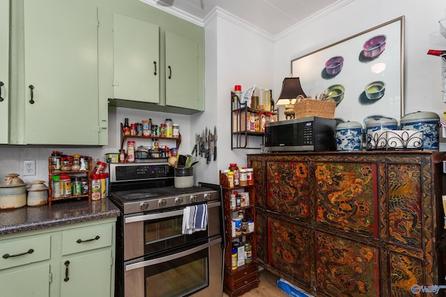 kitchen with decorative backsplash, green cabinets, ornamental molding, and stainless steel appliances