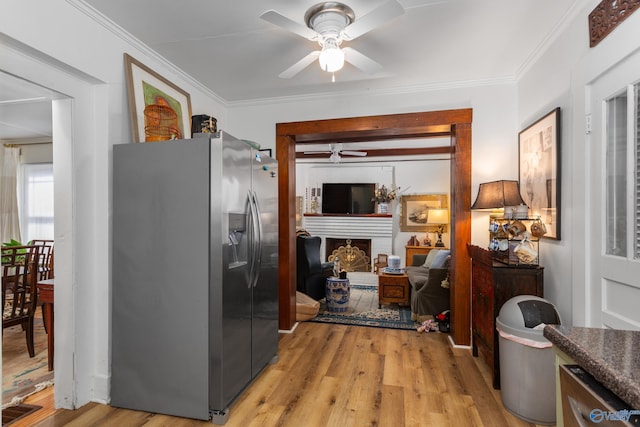 kitchen with stainless steel fridge with ice dispenser, light hardwood / wood-style flooring, and ornamental molding