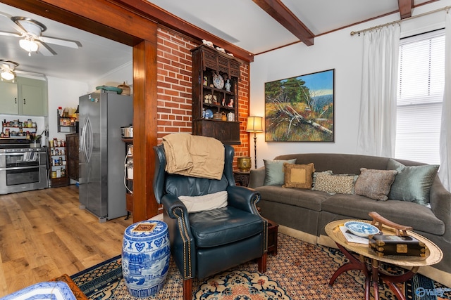 living room featuring hardwood / wood-style floors, ceiling fan, beam ceiling, and ornamental molding