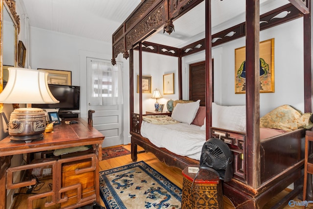 bedroom featuring hardwood / wood-style flooring and crown molding