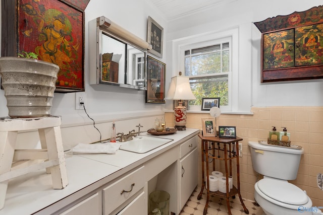 bathroom with vanity, toilet, and tile walls