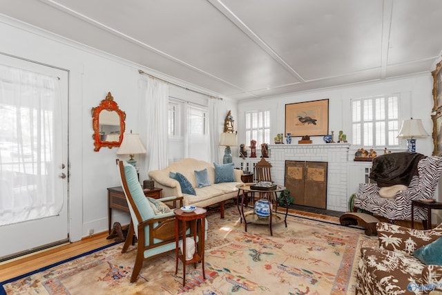 living room with light hardwood / wood-style floors and a brick fireplace