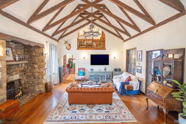 living room featuring a stone fireplace, high vaulted ceiling, and wood-type flooring