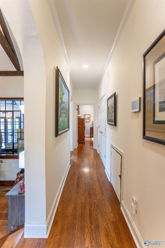 corridor with ornamental molding and dark hardwood / wood-style floors