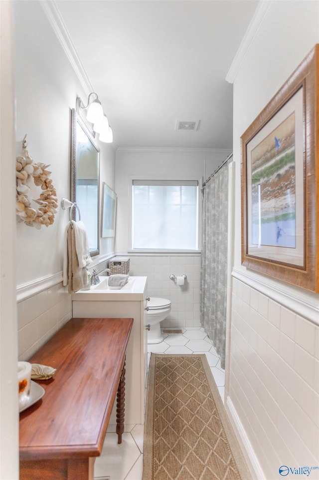 bathroom with vanity, tile patterned floors, toilet, and tile walls