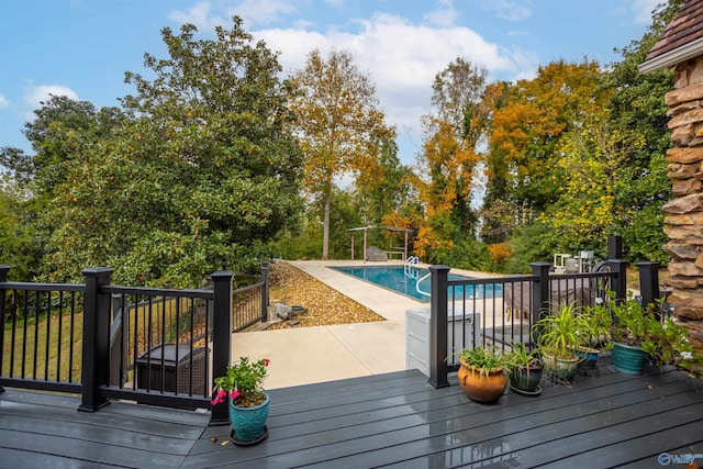 deck featuring a fenced in pool and a patio