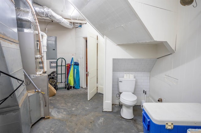 bathroom featuring electric panel, concrete floors, and toilet