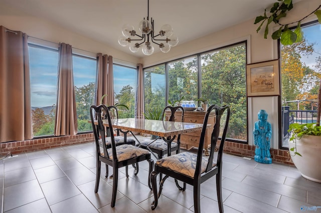 tiled dining space with a healthy amount of sunlight and an inviting chandelier