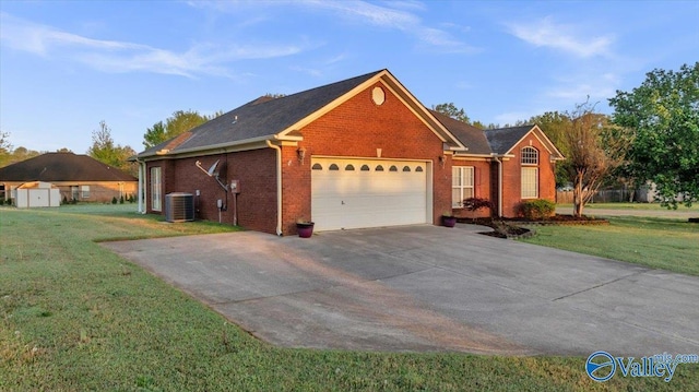 147 Singletree Dr, Hazel Green, AL 35750 - view of side of property with central AC, a lawn, brick siding, an attached garage, and driveway