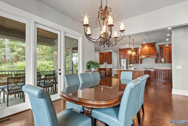 dining space with dark hardwood / wood-style flooring and an inviting chandelier