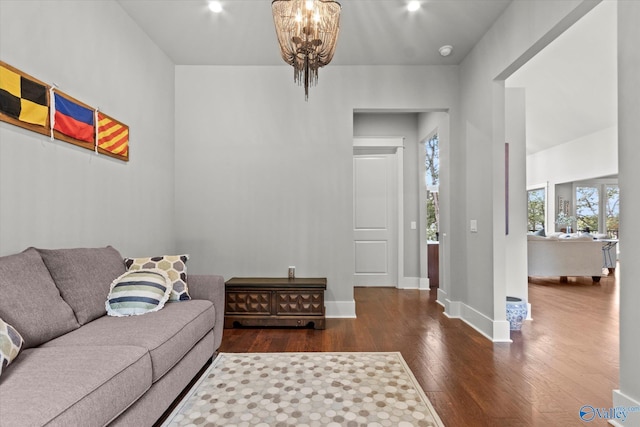 living room with dark wood-type flooring and a notable chandelier