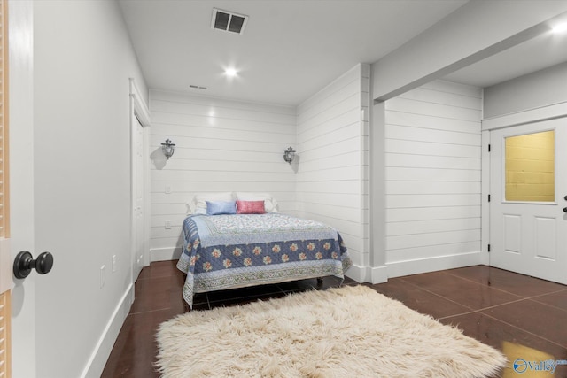 bedroom featuring wooden walls