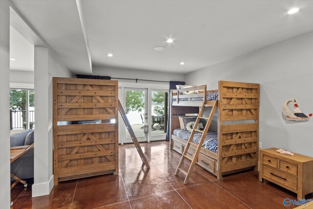 bedroom featuring dark tile patterned flooring, multiple windows, and access to outside