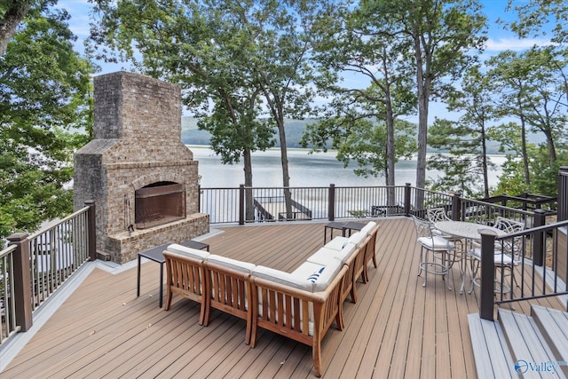 wooden terrace with a water view and an outdoor living space with a fireplace