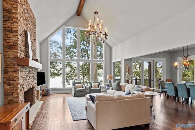 living room with dark hardwood / wood-style flooring, a notable chandelier, a fireplace, and high vaulted ceiling