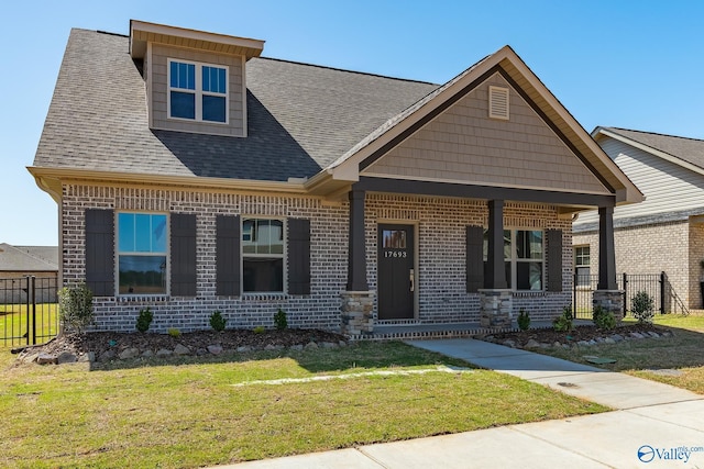 craftsman-style home with a front yard and a porch