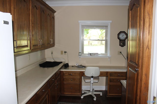 home office featuring ornamental molding and built in desk