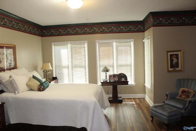 bedroom with multiple windows, dark hardwood / wood-style floors, and a textured ceiling