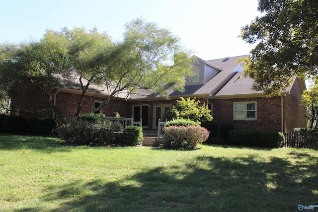 rear view of house featuring a yard