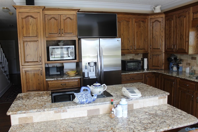 kitchen with light stone counters, appliances with stainless steel finishes, tasteful backsplash, and a kitchen island