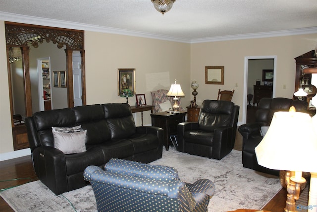 living room with decorative columns, a textured ceiling, crown molding, and hardwood / wood-style floors