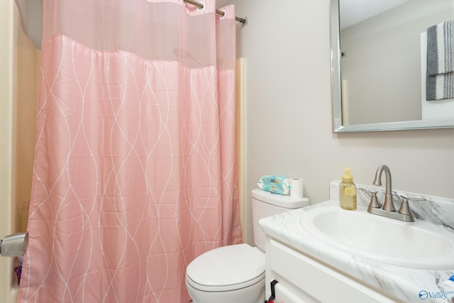 bathroom with vanity, curtained shower, and toilet