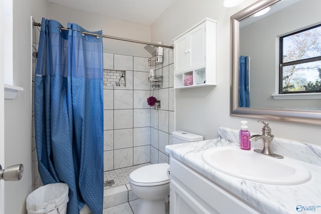 bathroom featuring tile patterned flooring, vanity, toilet, and curtained shower