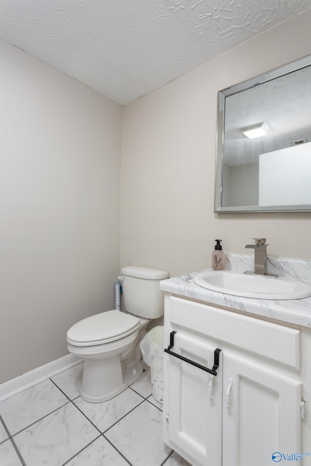 bathroom featuring vanity, a textured ceiling, and toilet