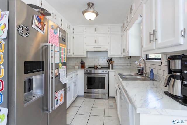 kitchen with white cabinets, appliances with stainless steel finishes, tasteful backsplash, and sink