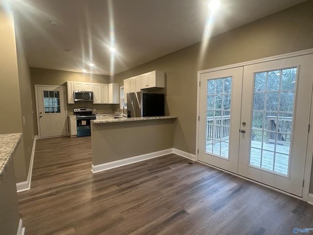 kitchen with stainless steel appliances, white cabinets, french doors, kitchen peninsula, and dark wood-type flooring