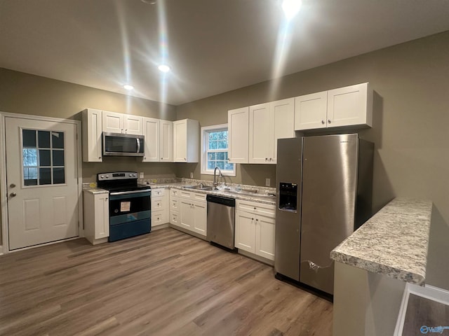 kitchen featuring white cabinetry, stainless steel appliances, hardwood / wood-style floors, and sink