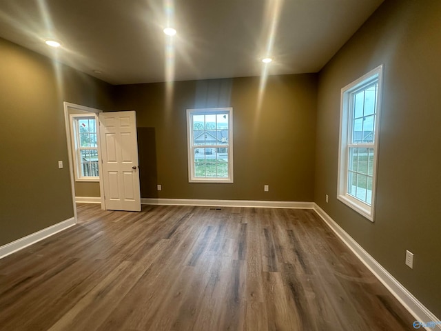 empty room featuring plenty of natural light and hardwood / wood-style floors