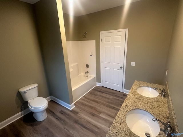 full bathroom with dual vanity, bathing tub / shower combination, wood-type flooring, and toilet