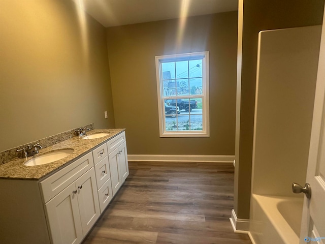 bathroom featuring dual vanity and hardwood / wood-style flooring