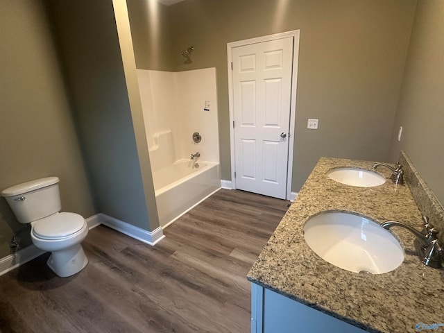 full bathroom featuring hardwood / wood-style flooring, double sink vanity, toilet, and tub / shower combination