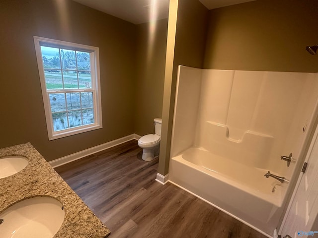 full bathroom with shower / washtub combination, toilet, hardwood / wood-style floors, and dual bowl vanity