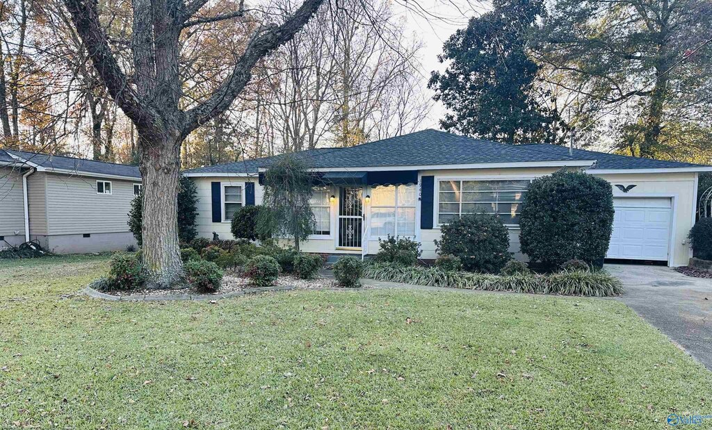 single story home with a front yard and a garage