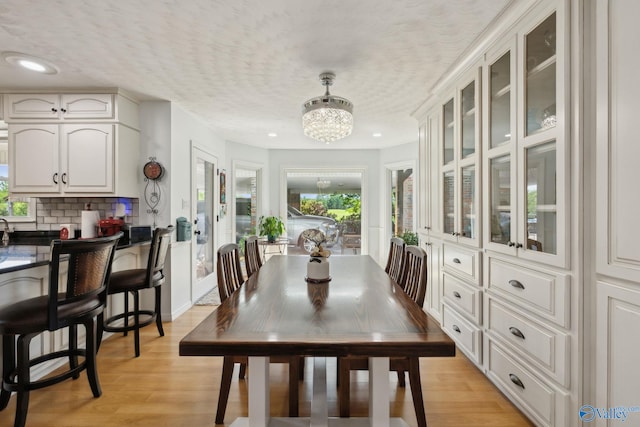 7734 Upper Snake Rd, Athens, AL 35614 - dining room featuring a textured ceiling, light wood-style flooring, and a chandelier