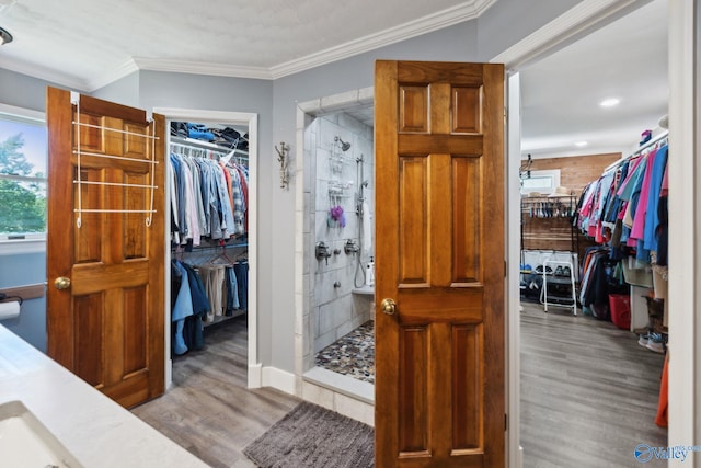 7734 Upper Snake Rd, Athens, AL 35614 - bathroom featuring crown molding, a stall shower, a walk in closet, and wood finished floors