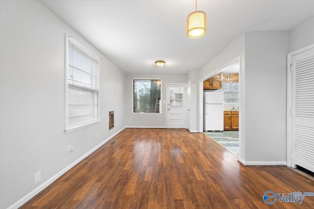 foyer entrance with baseboards and wood finished floors