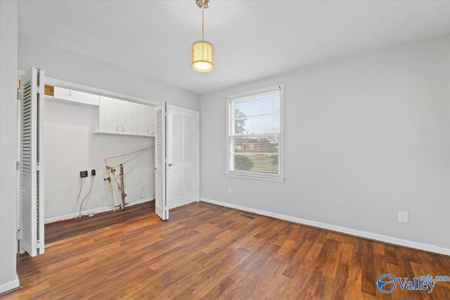 interior space with visible vents, wood finished floors, cabinet space, and baseboards